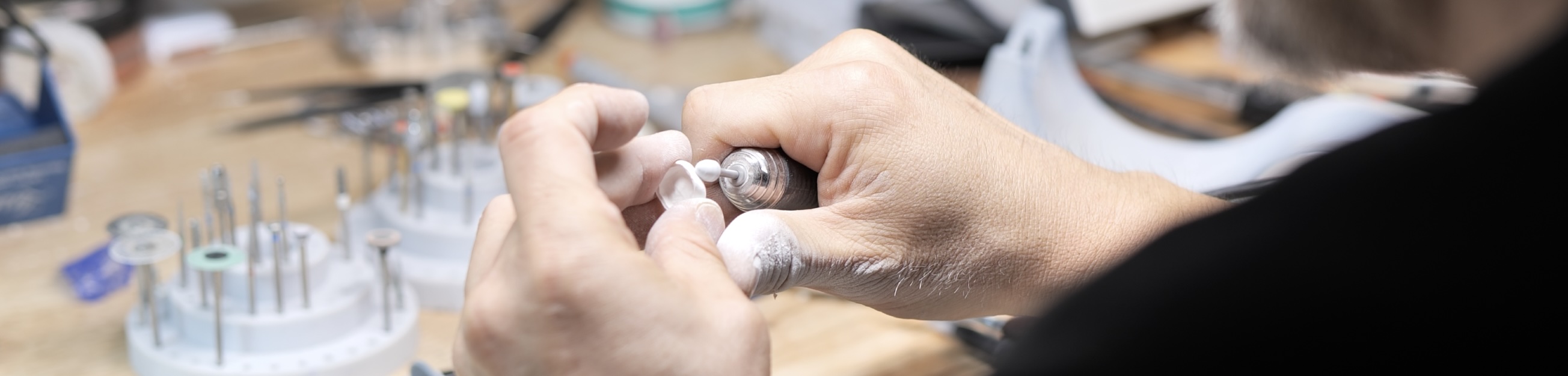 Our master ceramists craft custom veneers at the Atlanta Dental Spa lab, using advanced specialized tools. The detailed work takes place on a well-equipped workstation, highlighting the precision and skill involved in creating high-quality dental restorations.